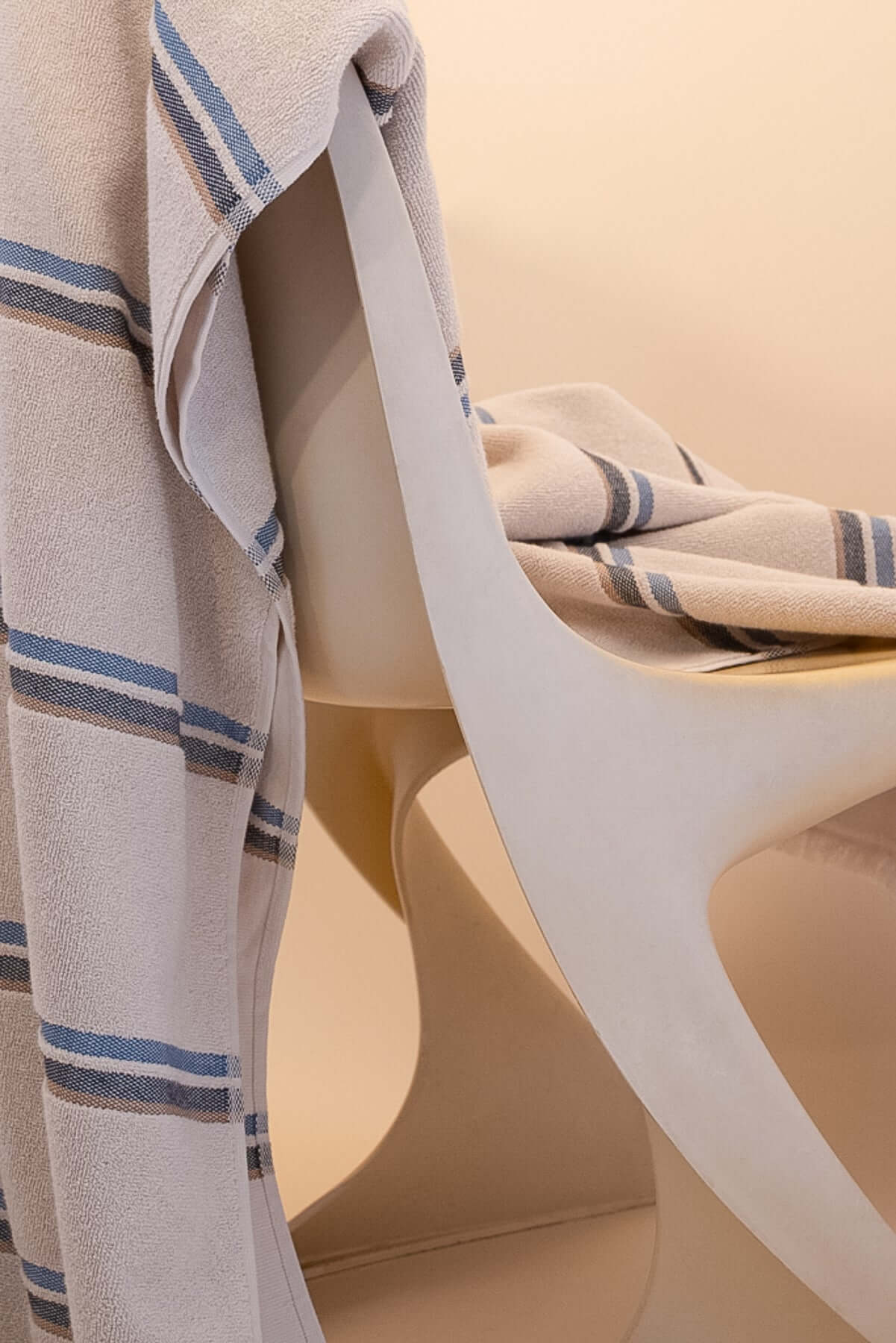Kobn Ecru towel with blue stripes draped on a chair