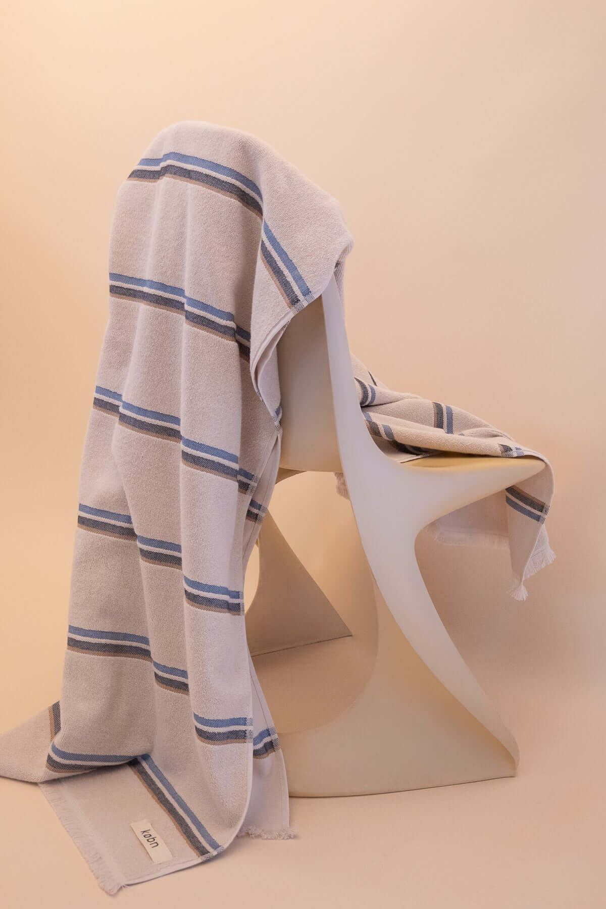 Kobn striped Ecru towel draped on a chair