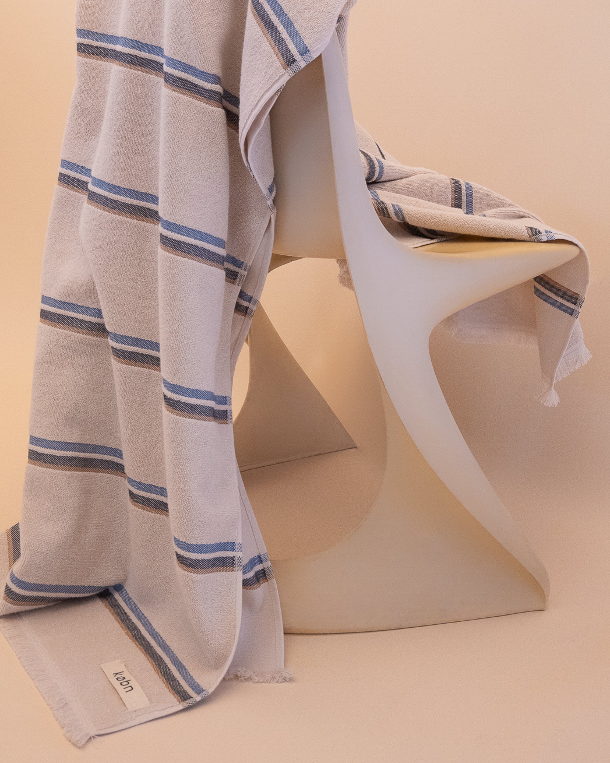 Kobn striped Ecru towel draped on a chair