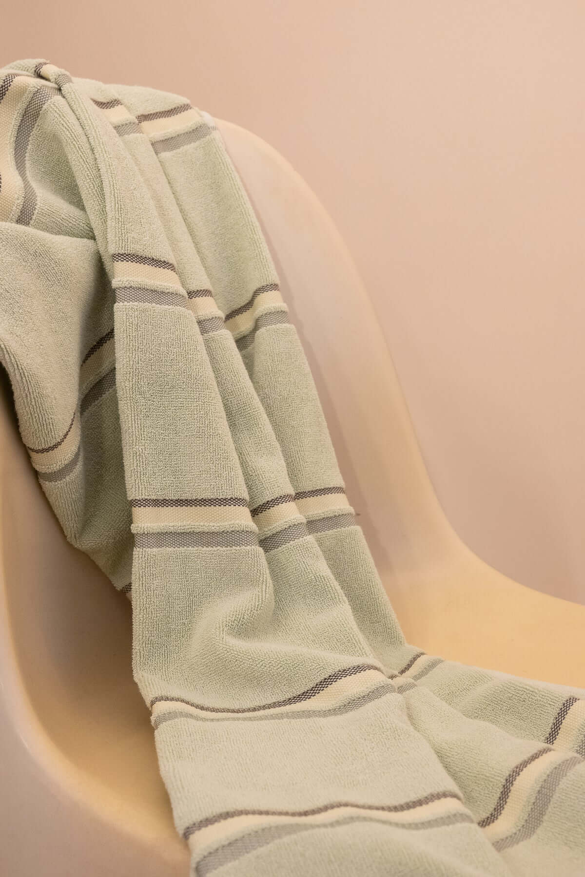Kobn Matcha towel draped on a chair after a swim