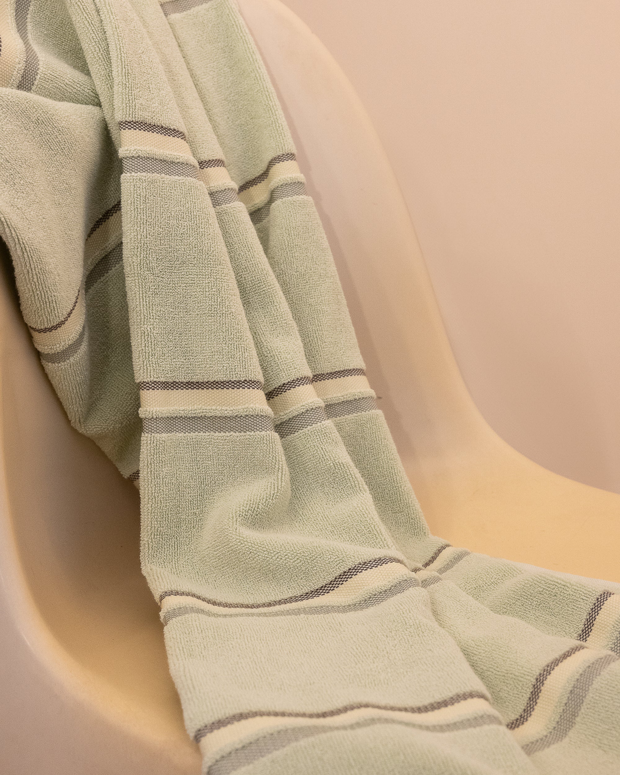 Kobn Matcha towel draped on a chair after a swim