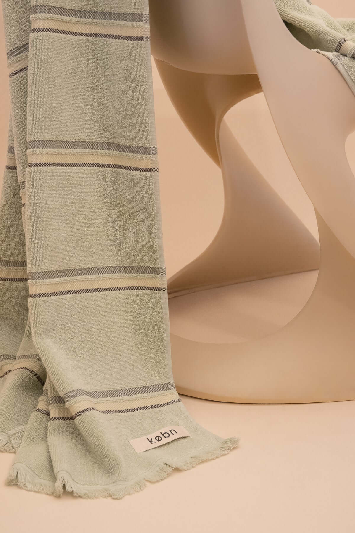 Kobn Matcha towel draped on a vintage Casella chair. Towel is lightweight and woven with  premium cotton. Sustainably made in Turkey. 