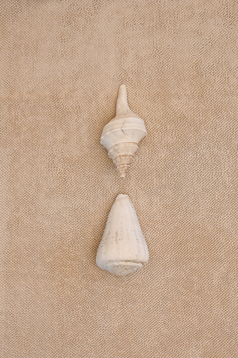 Kobn Sand Bath Mat laid flat with two shells on top. The weave is plush and chunky.