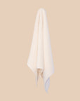 White hand  towel hanging against a beige background