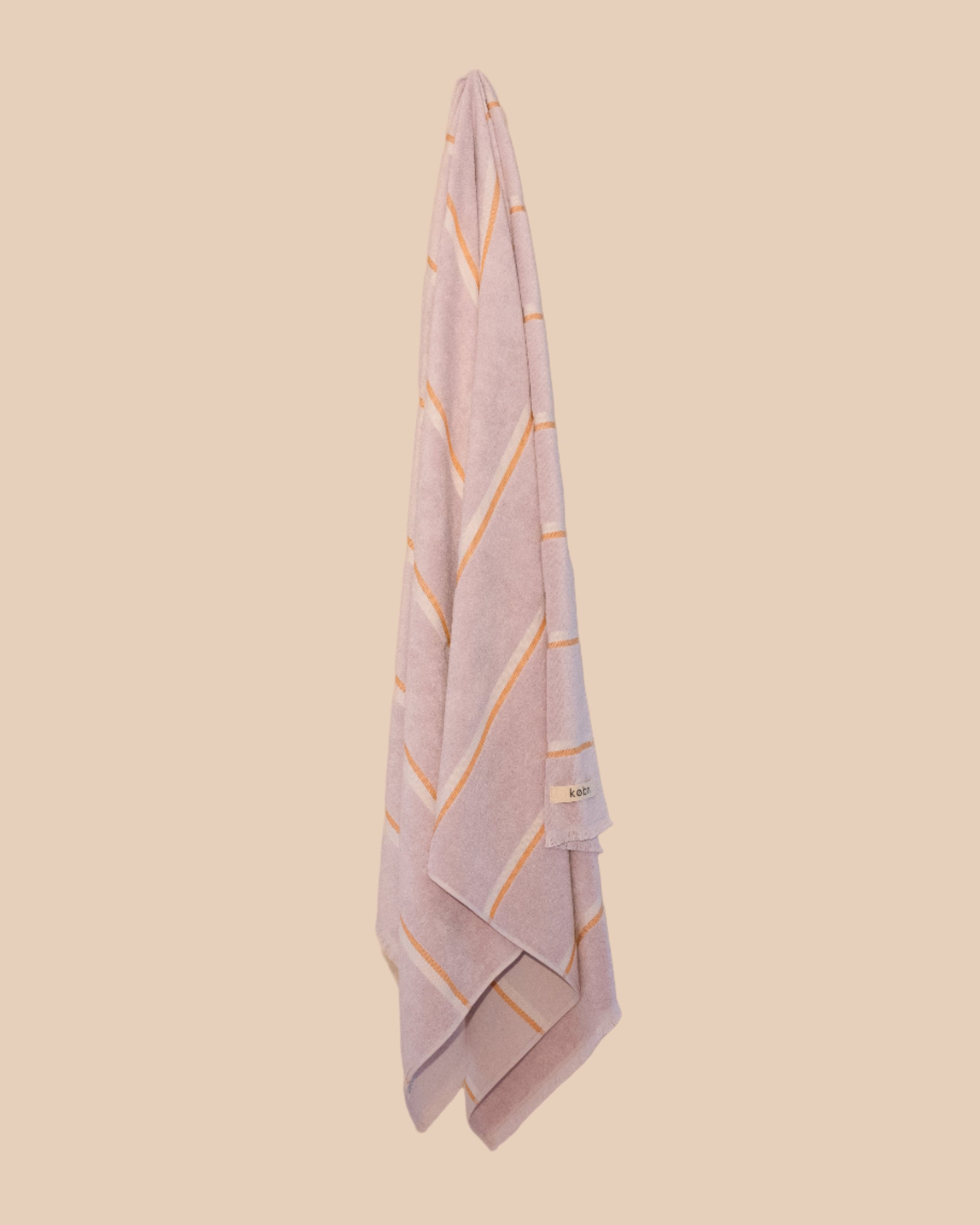 Lilac turkish towel by kobn hanging with marigold yellow stripes. 