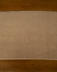 Beige textured bathmat on a wooden floor