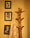 Wooden coat rack with a striped towel against a wall with framed pictures.