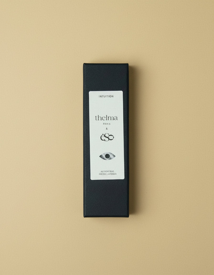 Black box of incense sticks on butter yellow background. 