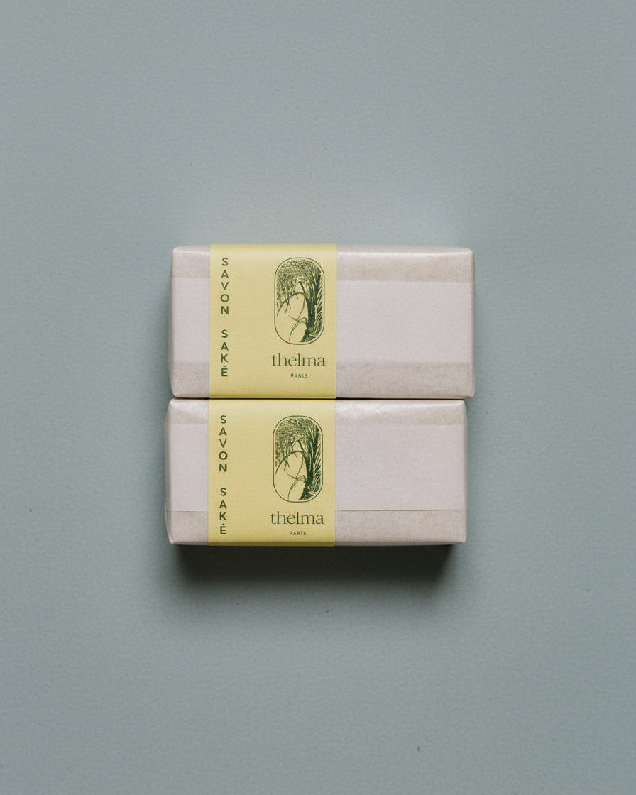 Two soap packages with yellow labels on a pale blue background